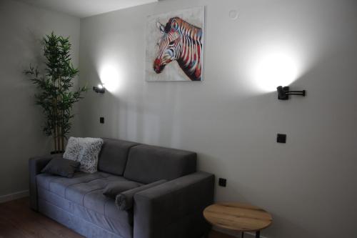 a living room with a couch and a painting of a zebra at Apartman Mist - Bela Reka Kopaonik in Brzeće