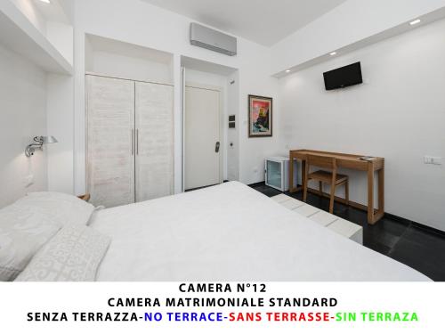 a bedroom with a white bed and a desk at I Tibei Guesthouse Affittacamere in Monterosso al Mare