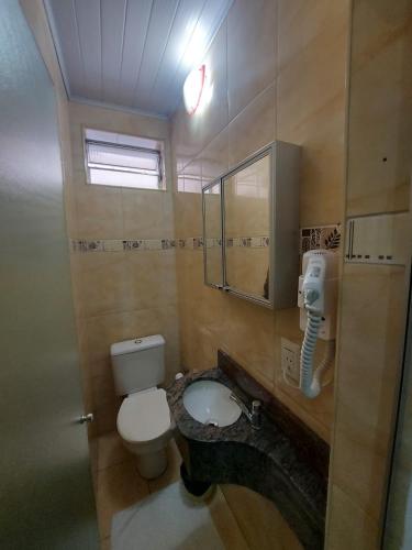 a bathroom with a toilet and a sink at Hotel Mooca in Sao Paulo