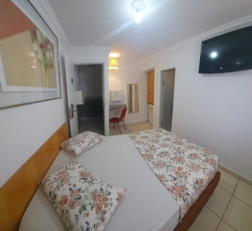 a hotel room with a bed and a chair at Hotel Mooca in Sao Paulo