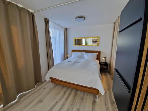 a bedroom with a large bed with white sheets at 7thHeaven centre suite FREE PARKING in the building in Bratislava