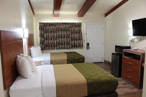 a hotel room with two beds and a television at Evergreen Inn and R.V. in Winnfield