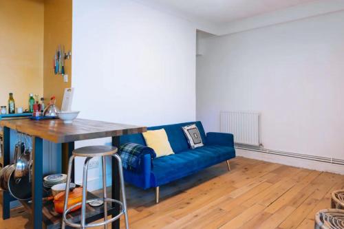 a living room with a blue couch and a table at Peaceful 1BD Flat with Private Garden Brighton! in Brighton & Hove