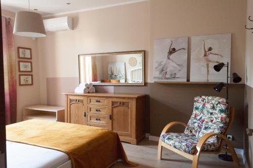 a bedroom with a bed and a chair and a mirror at Charisma in Haskovo