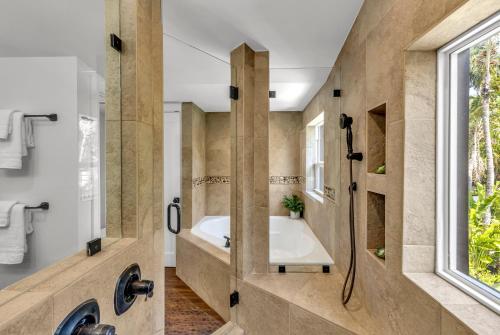 a bathroom with a tub and a shower at Special Pricing, Las Olas Retreat, Heated Pool, Golf and Family-Ready in Fort Lauderdale