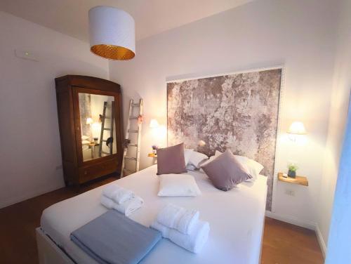 ein Schlafzimmer mit einem weißen Bett mit zwei Kissen in der Unterkunft Annamaria Rooms in Neapel