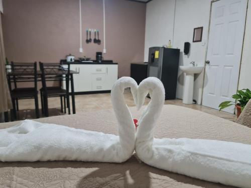 two white swans making a heart on a bed at Cabinas Guayabón #5, AC, La Fortuna San Carlos in Fortuna
