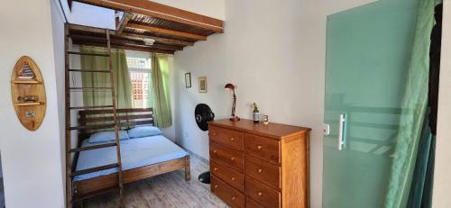 een slaapkamer met een stapelbed en een houten dressoir bij Casa da Praia - Casa em Arraial do Cabo - Monte Alto - Região dos Lagos - RJ in Arraial do Cabo