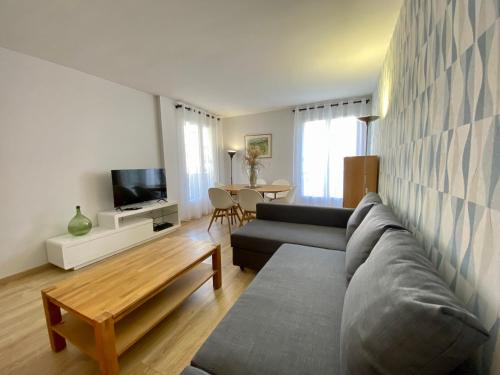 a living room with a couch and a table at Le Beaugency Near Paris & Disneyland in Champs-Sur-Marne