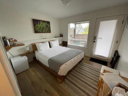 Un dormitorio con una cama grande y una ventana en Sounds of the Sea en Ucluelet