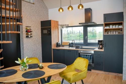 a kitchen with a wooden table and yellow chairs at Welcome House Eger in Eger