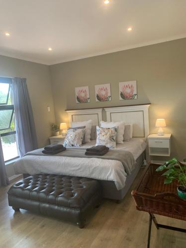a bedroom with a large bed with a black leather seat at Langebaan Golf Studio B1 - Langebaan Golf Estate in Langebaan