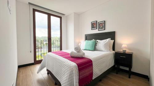 un dormitorio con una cama con un animal de peluche en L3A 404- Apartamento 2 dormitorios en Cayalá 4 huéspedes, en Guatemala