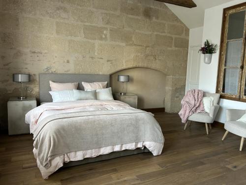 La Fosse-de-Tigné的住宿－Château du Beugnon，一间卧室设有一张大床和石墙