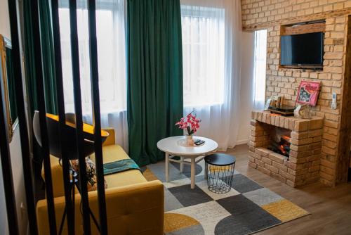 a living room with a couch and a fire place at Czocha Studio Apartment in Leśna
