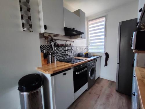 a small kitchen with a stove and a washer at Origami • Hippod. Enghien • 30 mn Paris in Eaubonne