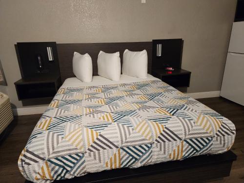 a bedroom with a large bed with a colorful comforter at Studio 6 Sacramento, CA Natomas in Sacramento