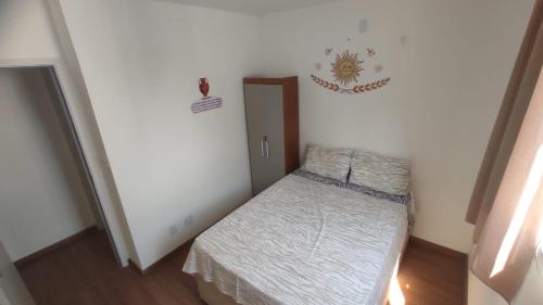 a small bedroom with a bed and a door at Apartamento Novinho Aeroporto JF in Juiz de Fora