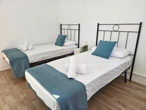 two beds with blue and white pillows in a room at Apartamento Bilbao in Bilbao