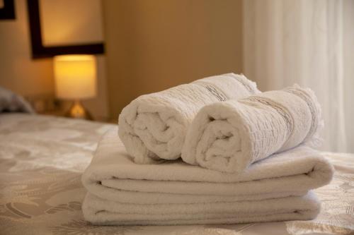 a pile of towels sitting on top of a bed at BURGO NUEVO Ático de lujo en pleno centro con terraza y vistas - leonapartamentos in León