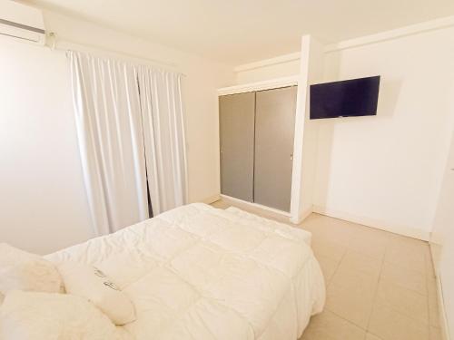 a white bedroom with a bed and a window at TIDES Apart de playa in Ostende