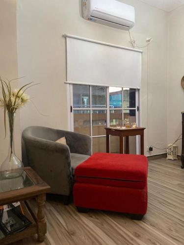 uma sala de estar com uma cadeira e um repousa-pés vermelhos em EXCELENTE PROPIEDAD em Paso de los Libres
