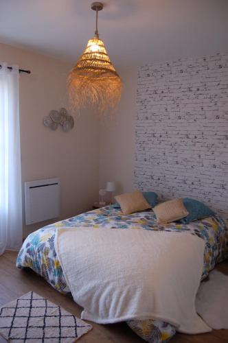 1 dormitorio con cama y lámpara de araña en gite de tounette 