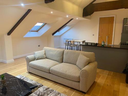 a couch sitting in a living room with skylights at The Orchards in Elland