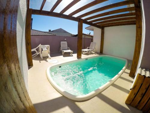 a bath tub sitting on a deck with a patio at Residencial Viva Torres - Casas com 2 Dorms, Ar e Piscina Aquecida na Praia da Cal in Torres