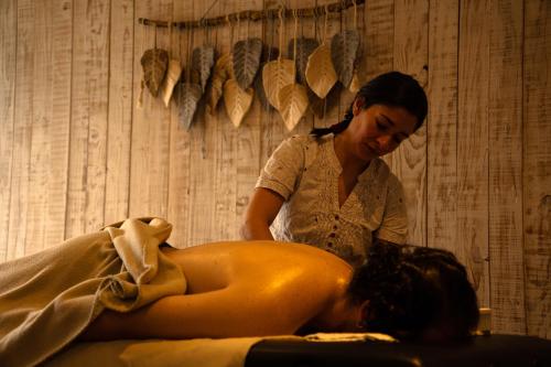 a woman is giving a woman a massage at Quisquito Lodge & Spa - Punta de Lobos - Tina 24 Hrs in Pichilemu