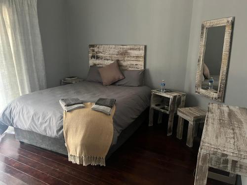- une chambre avec un lit avec un miroir et une table dans l'établissement Plantation House, Boksburg, à Boksburg
