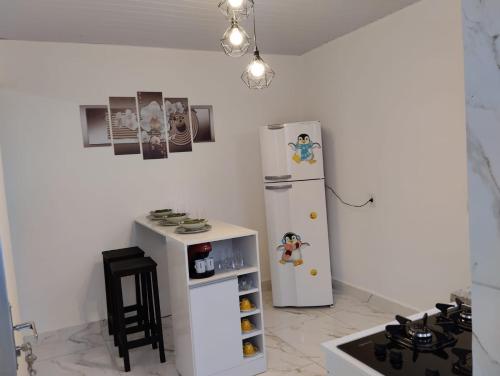 uma cozinha com um frigorífico branco e um pequeno fogão em Simples e Aconchegante em Mogi das Cruzes