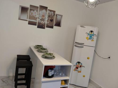 a small kitchen with a refrigerator and a small table at Simples e Aconchegante in Mogi das Cruzes