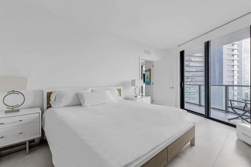 um quarto branco com uma cama grande e uma janela em Exclusive One-bedroom High-rise in Miami em Miami
