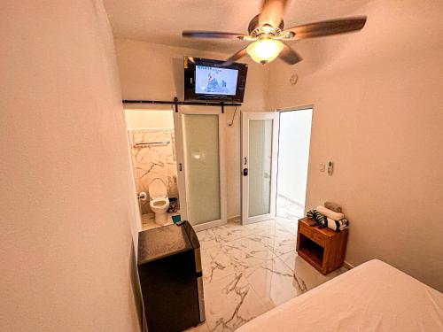 a bedroom with a ceiling fan and a tv on the wall at OMERO Ocean Park in San Juan