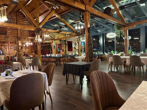 a restaurant with tables and chairs in a room at Hotel Antika in Peje