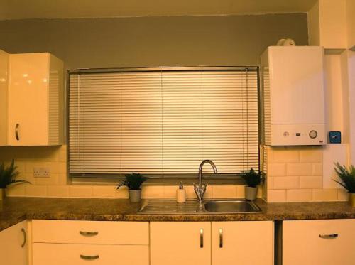 a kitchen with a sink and a window at Beautiful 3 Bedroom House Coventry in Coventry