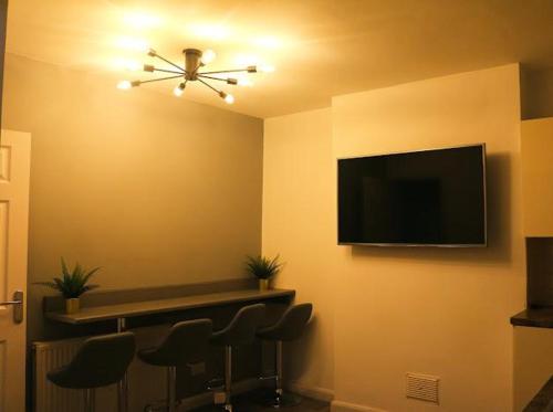 a room with chairs and a flat screen tv at Beautiful 3 Bedroom House Coventry in Coventry