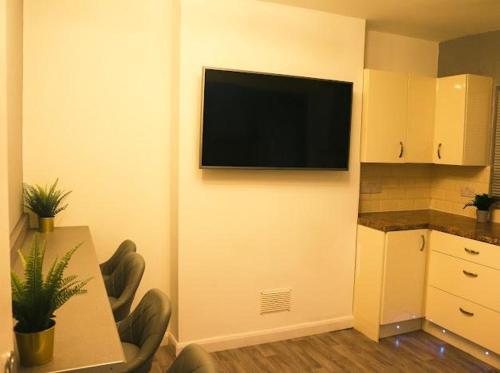 a room with a flat screen television on a wall at Beautiful 3 Bedroom House Coventry in Coventry