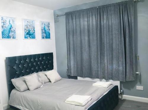 a bedroom with a bed with two towels on it at Beautiful 3 Bedroom House Coventry in Coventry