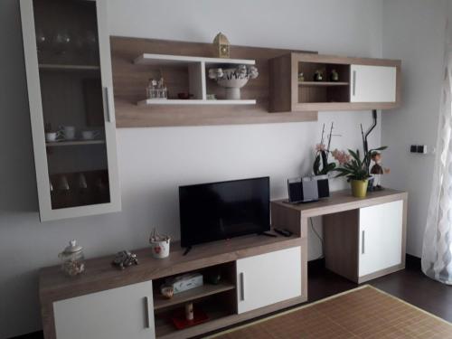 a living room with a tv on a wall at Atico vistas mar in Ribeira