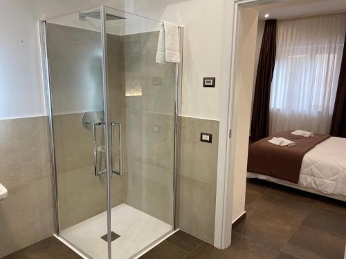 - une douche avec une porte en verre dans la chambre dans l'établissement B&B La Villa Cittanova, à Cittanova