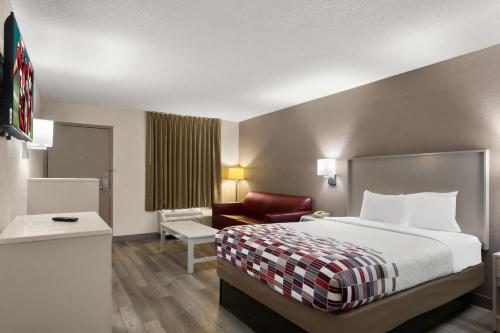 a hotel room with a bed and a chair at Red Roof Inn Kingsland in Kingsland