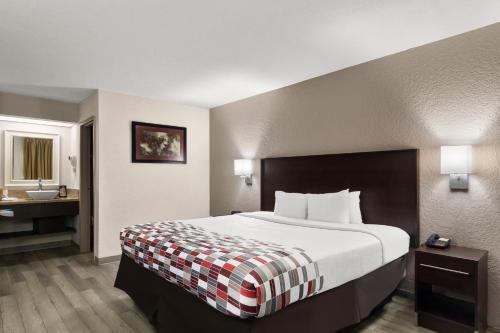 a hotel room with a large bed and a bathroom at Red Roof Inn Kingsland in Kingsland
