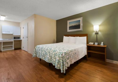 a hotel room with a bed and a kitchen at HomeTowne Studios by Red Roof Orlando - UCF Area in Orlando