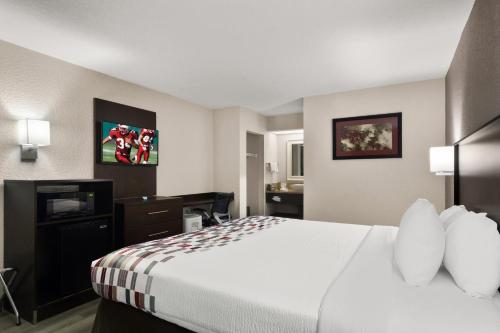 a hotel room with a large bed and a television at Red Roof Inn Kingsland in Kingsland