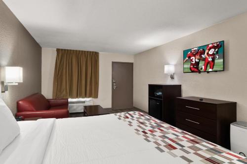 a hotel room with a bed and a living room at Red Roof Inn Kingsland in Kingsland