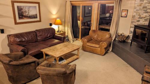 a living room with couches and chairs and a table at Cozy Townhouse on the main bus line in Breckenridge