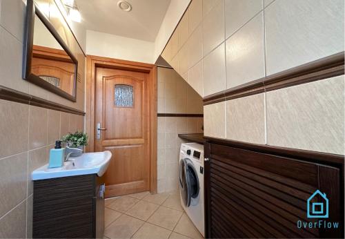 a bathroom with a sink and a washing machine at Mickle Room in Gdańsk