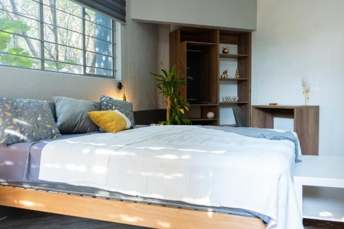 een slaapkamer met een groot wit bed met blauwe kussens bij Centro Histórico - Suite 5 Doble de Lujo Cama Doble King Size in Mexico-Stad